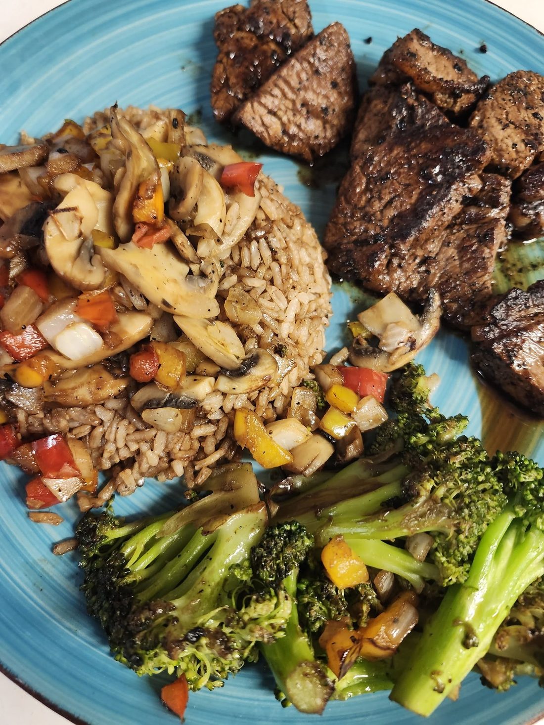 Grilled steak tips over rice with vegetables