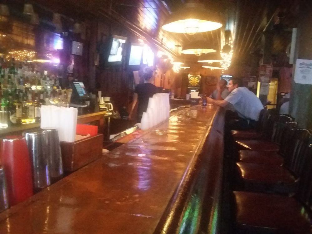 The warm, dimly lit length of The Tavrne's bar